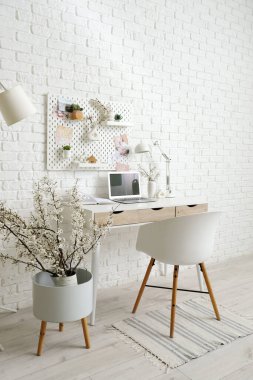 Çalışma yeri, tahta ve çiçek açan dalları olan şık bir ofis.