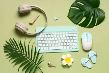 Fare, kulaklık ve yeşil arka planda plaj dekoru olan bilgisayar klavyesi