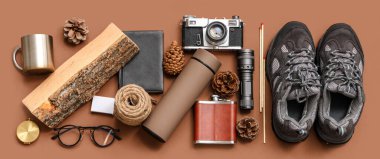 Modern termos, ayakkabı, farklı seyahat ögeleri ve renk arkaplan üzerinde çam kozalakları ile kompozisyon