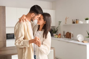 Mutlu genç çift evde dans ediyor.