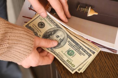 Kadın dergilerde dolar banknotları saklıyor, yakın plan.