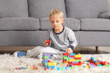 Sevimli küçük çocuk renkli oyuncak tuğlalarla oynuyor.