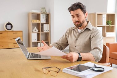 Ofisteki görevinden alınması emrini veren genç adam üzgün.