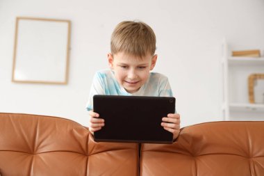 Evinde modern tablet bilgisayarı olan sevimli bir çocuk.