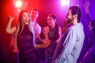 Gece kulübünde dans eden mutlu genç çift.