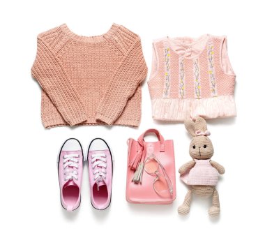 Beyaz arka planda oyuncak olan şık çocuk kıyafetleri.