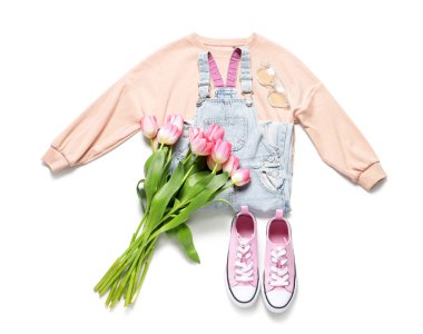 Beyaz arka planda laleleri olan şık çocuk kıyafetleri.