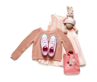 Beyaz arka planda oyuncak olan şık çocuk kıyafetleri.