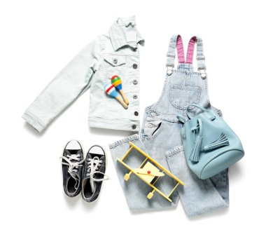 Beyaz arka planda oyuncakları olan şık çocuk kıyafetleri.