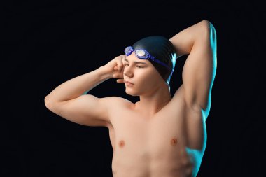 Siyah arka planda gerinen erkek yüzücü