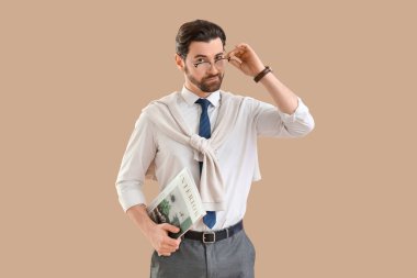 Bej arka planda iç dergisi olan yakışıklı bir iş adamı.