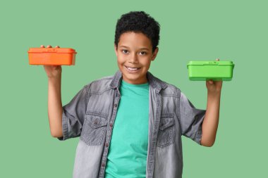 Yeşil arka planda beslenme çantası olan sevimli Afro-Amerikalı çocuk.