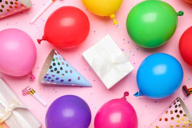 Farklı hava balonlarıyla kompozisyon, hediye kutuları ve pembe arka planda konfeti, yakın plan.