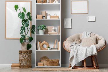 Kitaplık, koltuk ve çerçeveli aydınlatma odasının içi