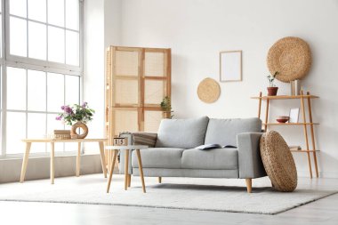 Gri kanepe ve kahve masası oturma odasının iç tarafında.