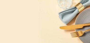 Bej arkaplan üzerinde altın çatal bıçak seti ile güzel masa ayarları metin için boşluk, yakın çekim