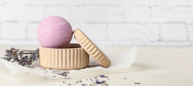 Hafif tuğla duvarın yanındaki masada lavanta banyosu bombası.