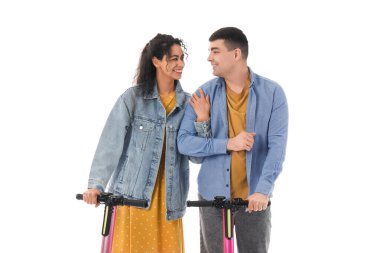 Beyaz arka planda modern elektrikli scooterları olan güzel genç bir çift.