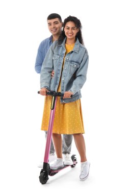 Beyaz arka planda modern elektrikli scooter kullanan güzel genç bir çift.