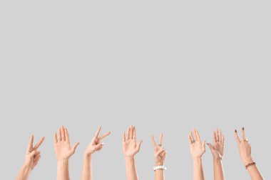 Birçok el arka planda zafer jesti gösteriyor.