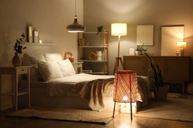 Şık bir yatak odası, rahat bir yatak ve geceleri parlayan lambalar.