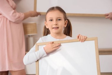 Boş çerçeveli küçük bir kız ve ailesi evde.