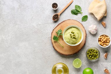 Limonlu, sarımsaklı ve gri arkaplanlı bir krakerli bezelye çorbası.