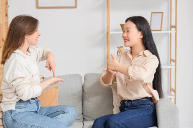 Evde işaret dili kullanan genç dilsiz kadınlar.