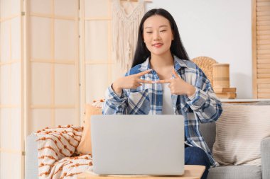 Evdeki video konuşmasında işaret dili kullanan Asyalı kadın.