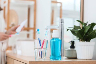 Diş fırçalı bardak ve banyodaki masada durulama.