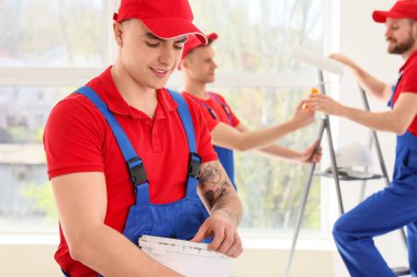 Odada bir kova boyası olan erkek dekoratör.