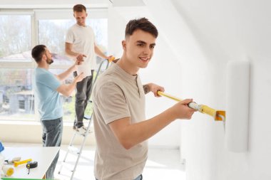 Odasında paten boyama duvarı olan genç bir adam.