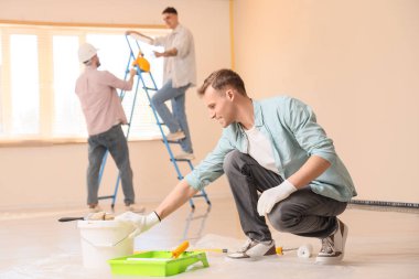 Odasında boya olan genç bir adam.