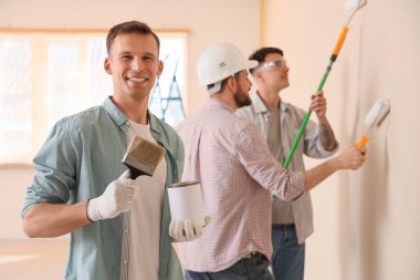 Fırçalı ve duvarları boyayabilen genç adam.