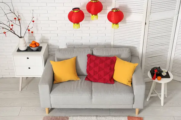 Çin Yeni Yılı için dekore edilmiş oturma odasının içi kanepe, masa ve katlanır ekran ile süslenmiş.