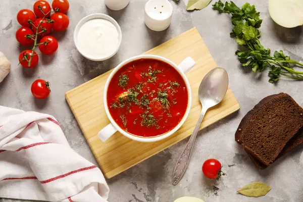Bir kase lezzetli Ukrayna çorbası ve gri arka planda malzemeler