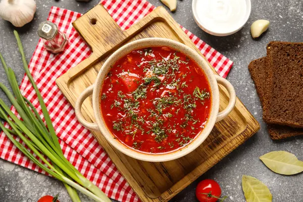 Bir kase lezzetli Ukrayna çorbası ve koyu arkaplanda malzemeler.