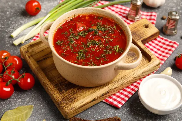 Bir kase lezzetli Ukrayna çorbası ve koyu arkaplanda malzemeler, yakın plan.