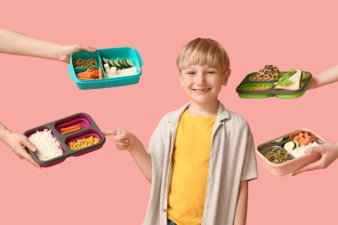 Pembe arka planda beslenme çantaları olan küçük çocuk ve kadın elleri.