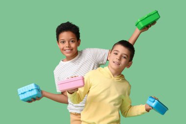 Yeşil arka planda beslenme çantaları olan sevimli çocuklar.