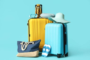 Renkli arka planda şık plaj aksesuarları olan bavullar