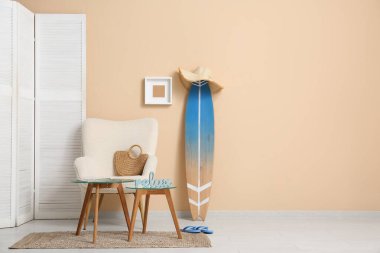 Beyaz koltuklu, kahve masalı ve sörf tahtalı şık bir oturma odası.