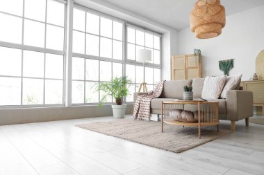 Oturma odasının içinde yumuşak kanepe, masa ve lambalar var.