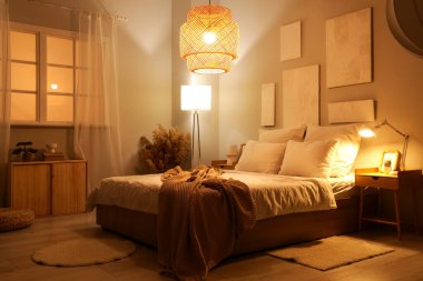 Karanlık yatak odasının içinde resimler, otlar ve parlayan lambalar var.