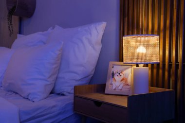 Geceleri karanlık yatak odasındaki çerçeveli parlayan lamba.