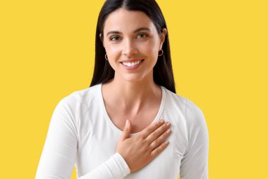 Sarı arka plandaki minnettar genç bayan.