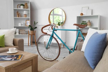 Oturma odasının içinde bisiklet, kanepe ve raf üniteleri var.