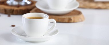 Beyaz masada bir fincan sıcak kahve, yakın plan.