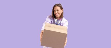 Güzel, genç, mutlu bir kadın. Mor arka planda koli kutusu ve kulaklıkları var.