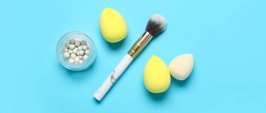 Mavi arkaplanda fırça ve fosforlu makyaj süngerleri